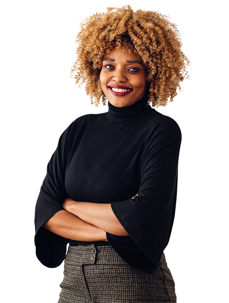 A person with curly hair is wearing a long-sleeve top and checkered pants, with arms crossed.