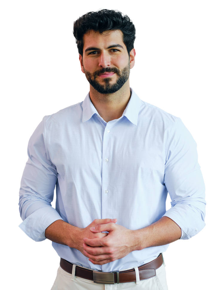 A person is wearing a button-up shirt with rolled-up sleeves, beige pants, and a brown belt, with hands clasped in front.