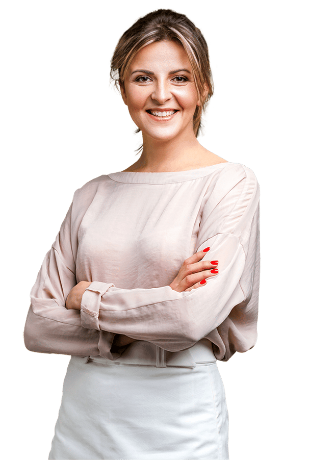 A person with arms crossed, wearing a long-sleeved blouse and a skirt.